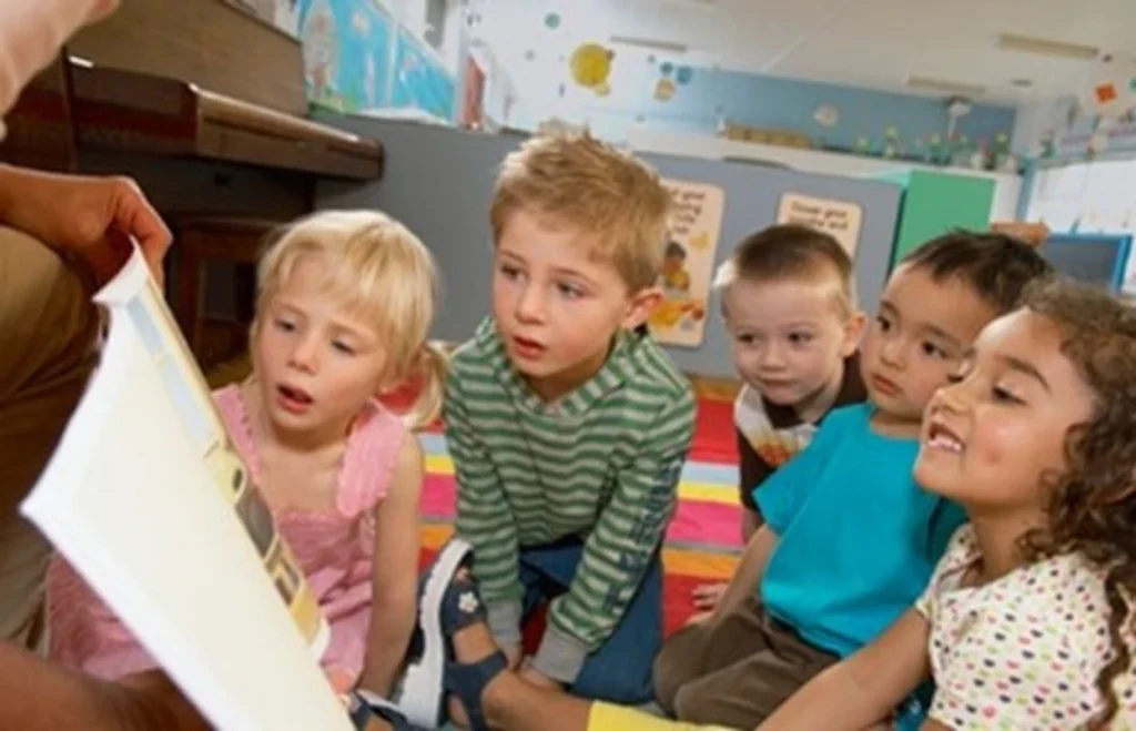 Children viewing illustrations from a Grace series book with curiosity and smiles
